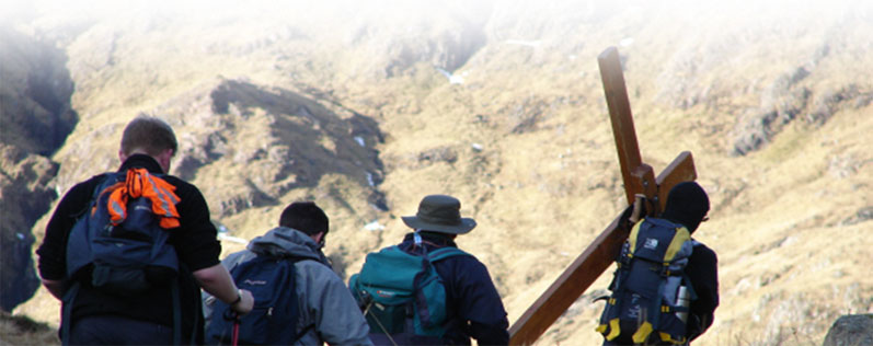 Image of hill walkers carrying a cross